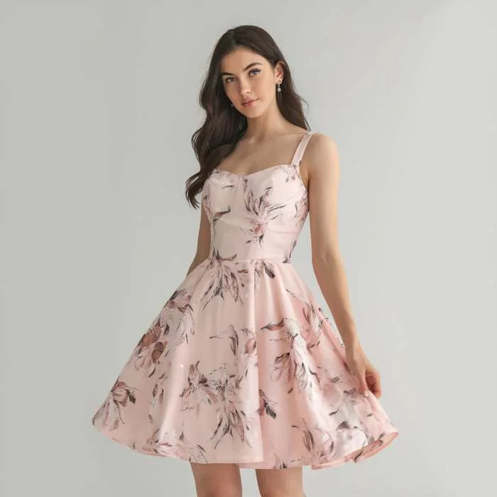 A stylish woman wearing a soft pink floral dress, highlighting romantic pastels as part of spring fashion trends that bring elegance and freshness to the season.